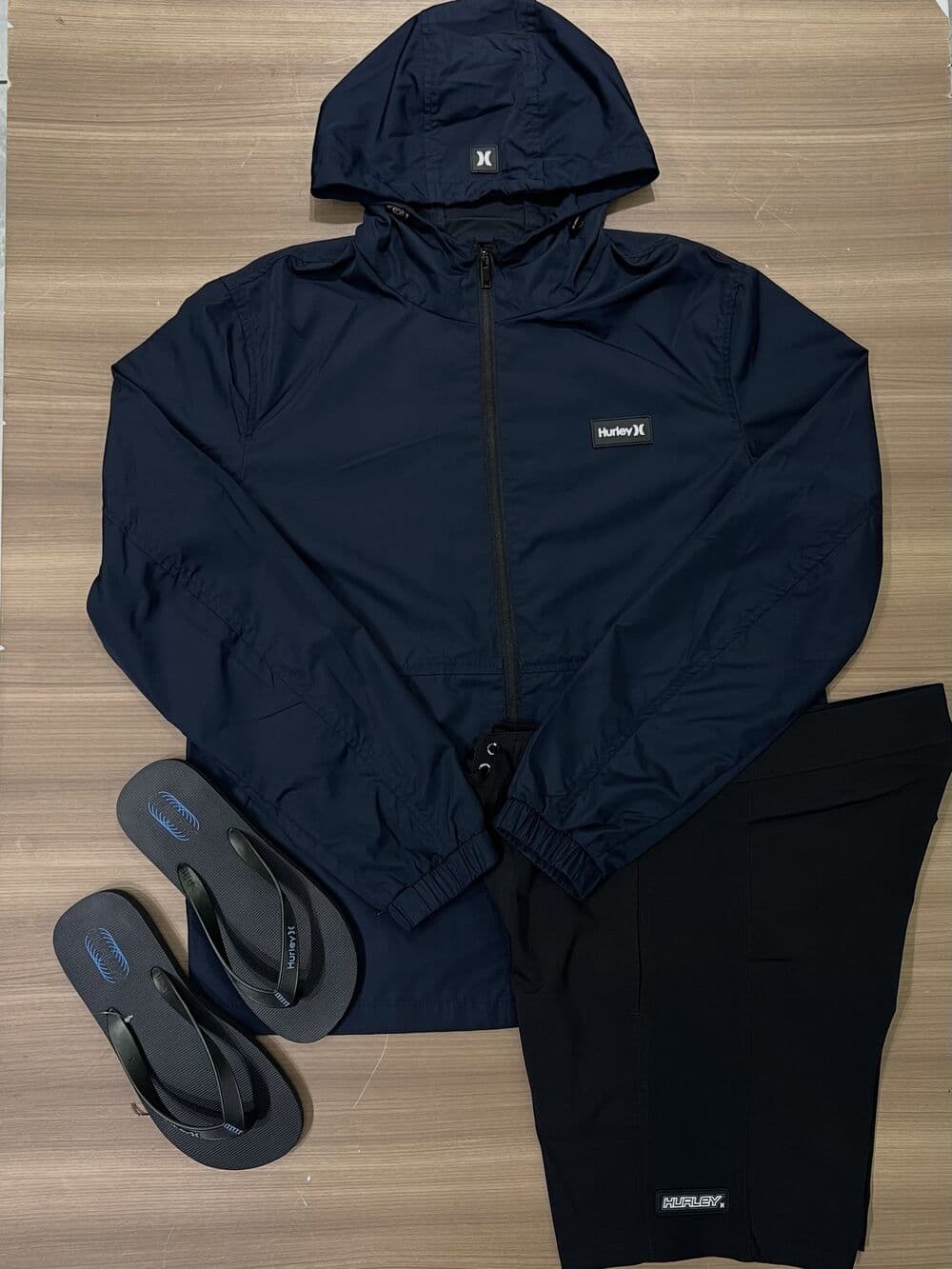 Casaco corta-vento Hurley azul-marinho com bermuda e chinelo